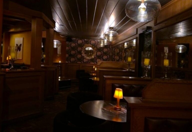 Interior of Del Rey at Villa Royale with dim lighting, wood accents, and intimate seating