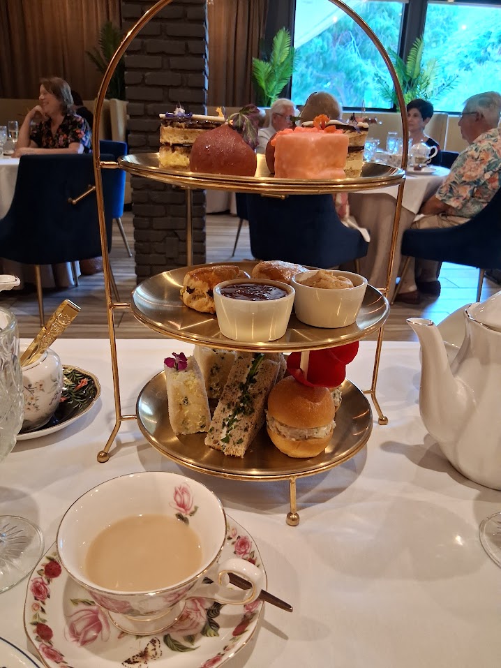 Tiered afternoon tea stand at Willie’s Modern Fare with pastries, scones, and sandwiches in the dining room