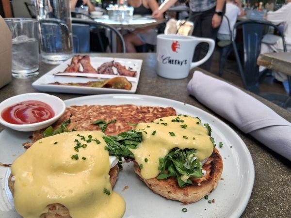 Blondie’s Eggs Benedict at Cheeky’s Palm Springs with hash browns and the bacon flight in the background.