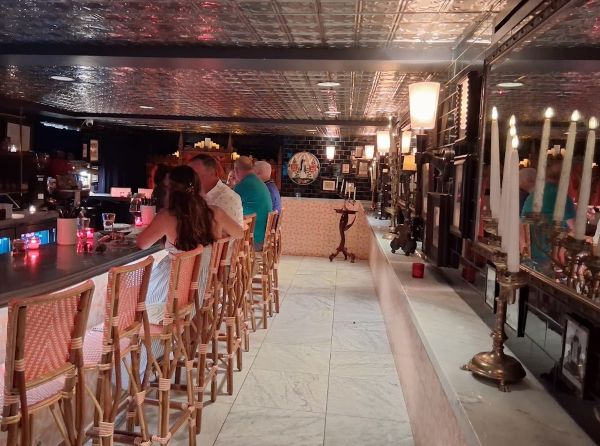 Guests seated at the Counter Reformation bar inside Parker Palm Springs, with candlelit décor, patterned ceiling, and intimate lighting.