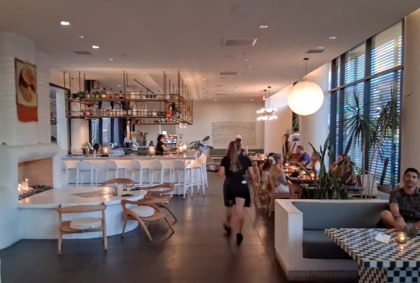 Interior of Maleza restaurant showing bar, seating, and warm lighting in a modern desert‑inspired space.