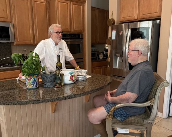Chef Christophe speaking with a client in a home kitchen during a cooking session