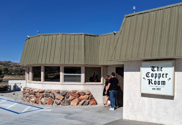 The Copper Room in Yucca Valley against air strip and a plaque stating 1957