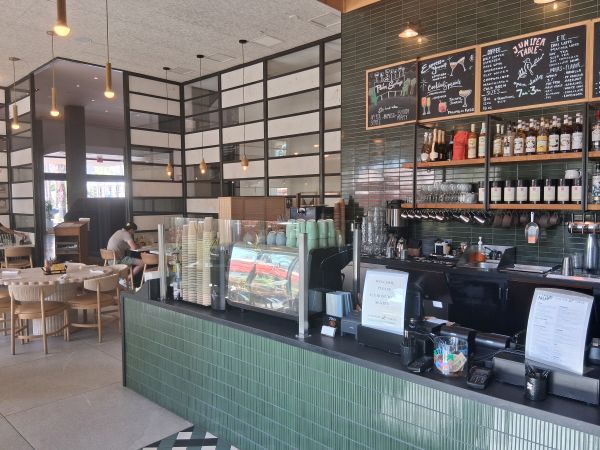 A shot of the interior of Juniper Table at the Palm Springs Kimpton Rowan. The coffee counter stretches out to the dining room