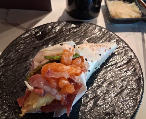 Soy‑paper hand roll filled with salmon, tuna, avocado, and tempura shrimp at Ponzu Sushi in Palm Springs.