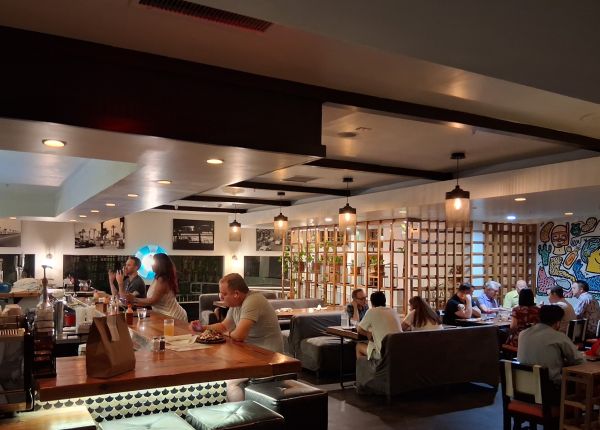 Interior of El Jefe Desert Cantina with diners seated at booths and the bar under warm pendant lighting.