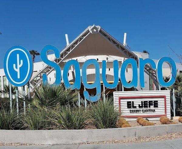 Exterior signage for The Saguaro Palm Springs and El Jefe Desert Cantina surrounded by desert landscaping.