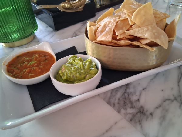 Fresh tortilla chips with house‑made salsa roja and guacamole at Colony Club.