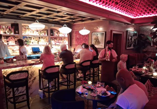 Guests seated at the illuminated marble bar inside Beaton's cocktail lounge in Palm Springs.