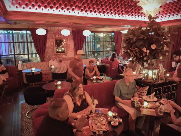 Interior dining room at Beaton's featuring red velvet seating, candlelit tables and Parisian-inspired decor.