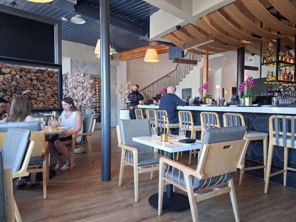 Interior dining room and bar area at Yozu Asian Bistro on El Paseo in Palm Desert featuring Desert Modern design, wood accents, open seating, and a central bar.