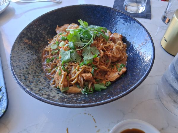 Spicy Garlic Noodles with Jidori Chicken at Yozu Asian Bistro featuring noodles tossed in sambal, ginger, and black garlic butter.