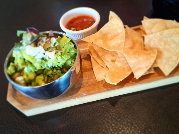 The Delicias Guacamole with pepitas, mango, and cilantro, with chips and salsa