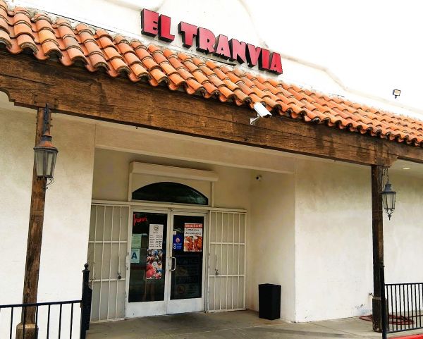 Front entrance of El Tranvia Restaurant in Coachella with a red tile roof and red sign above glass doors