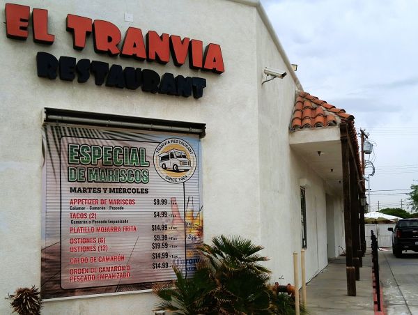 Side wall of El Tranvia Restaurant in Coachella with a Since 1969 food truck logo and a seafood specials banner