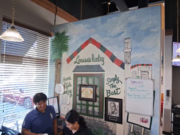 Host stand with a painted wall mural at Louise's Pantry in La Quinta