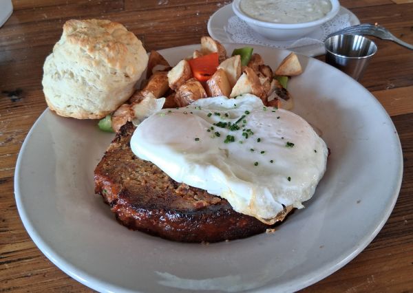 Meatloaf & Eggs with seared meatloaf, a biscuit, home fries and a side of gravy at Wilma & Frieda in Palm Springs.